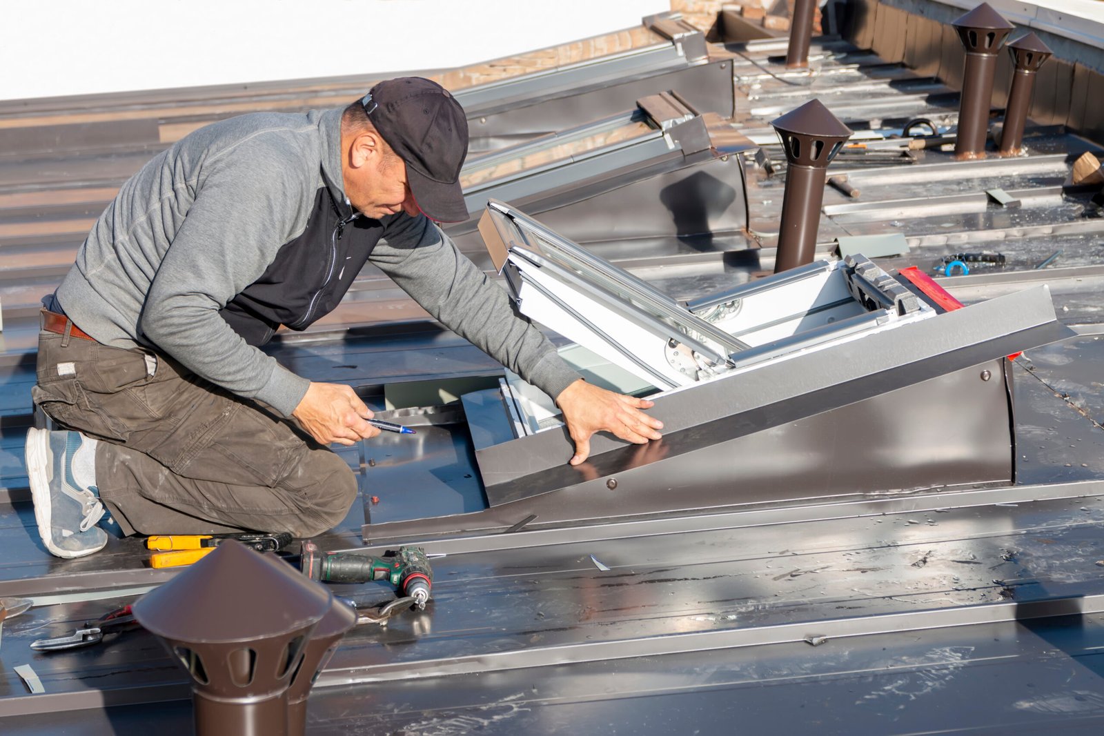 durham-roof-leak-repair A roofing contractor covers the roof skylight window with sheet metal in Durham, On
