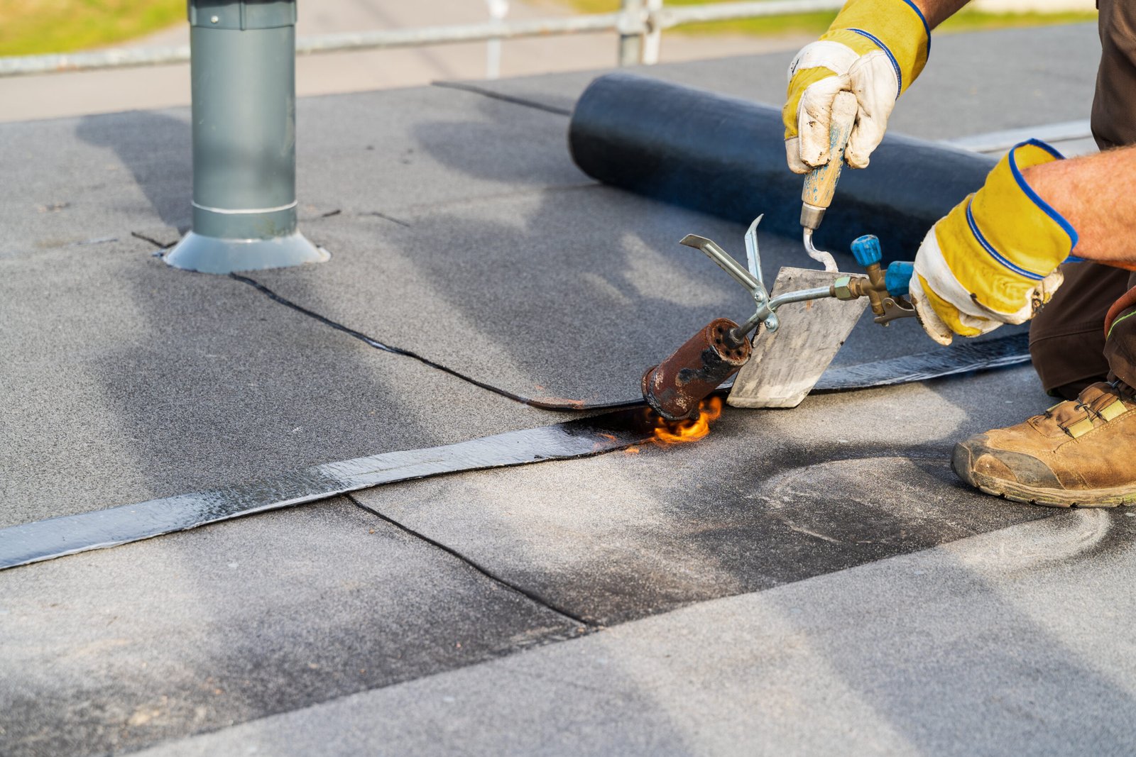 durham-roof-leak-repair Roofer repairing leak by Heating and melting bitumen roofing on a Flat roof in Durham.